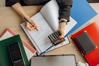 Accountant analyzing financial documents with a calculator on a desk, highlighting business tasks.